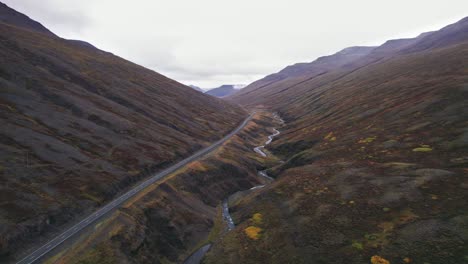 Luftaufnahme:-Leere-Straße-Ohne-Autos-Entlang-Der-Isländischen-Ringstraße,-Einer-Malerischen-Autobahn-Durch-Eine-Malerische,-Abgelegene-Fjordregion,-Die-In-Der-Ferne-Zu-Nebel-Und-Dunst-Führt