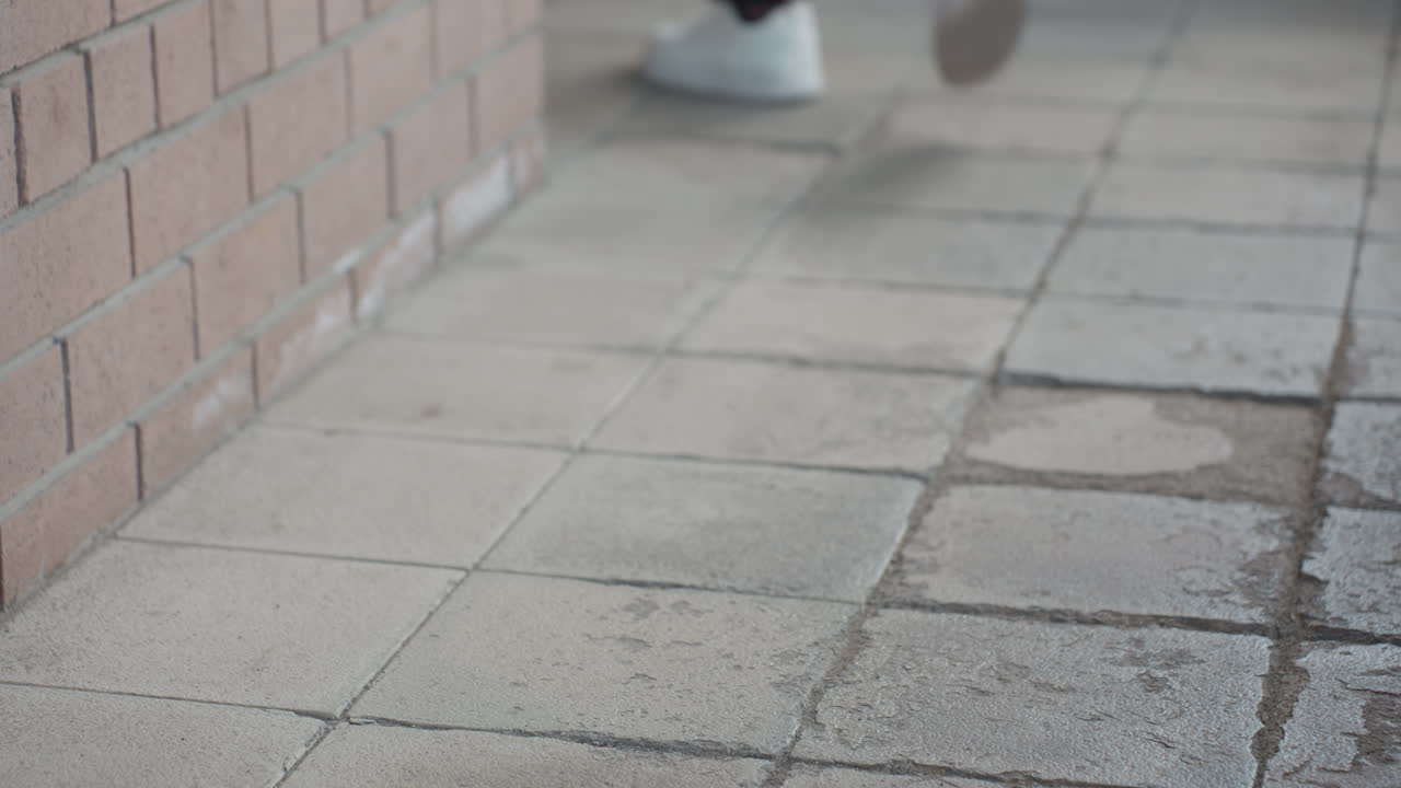 close view shows white sneakers lifting onto concrete step, heel in focus, Achilles visible above sock, motion blur conveys upward climb on rough stair with clean footwear contrasts grey surface