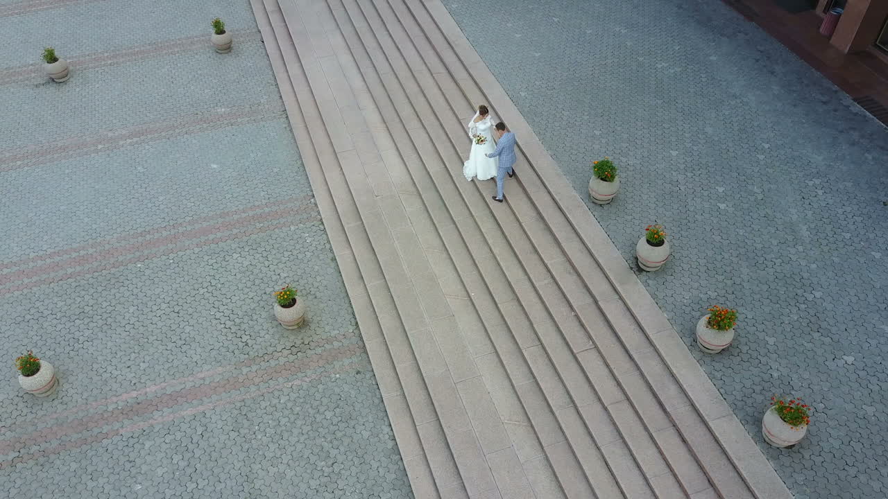 Aerial view. Just married couple walking in the city. Beautiful bridal couple