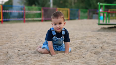 toddler playing in the sand at the playground