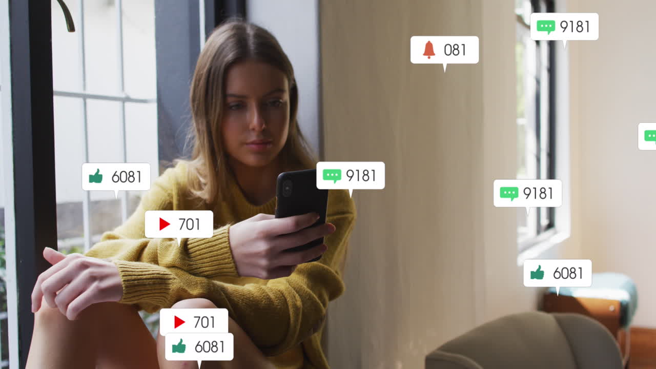 Animation of social media text and icons over caucasian woman with smartphone at home