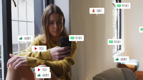 Animación-De-Texto-E-íconos-De-Redes-Sociales-Sobre-Una-Mujer-Caucásica-Con-Un-Teléfono-Inteligente-En-Casa