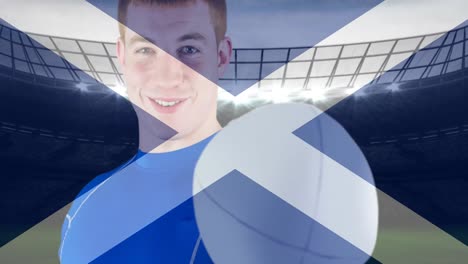 animation of flag of scotland over happy caucasian male rugby player at stadium