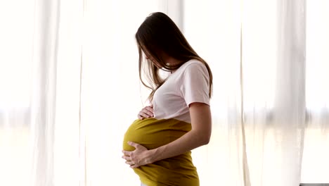 cheerful woman caressing belly in expectancy