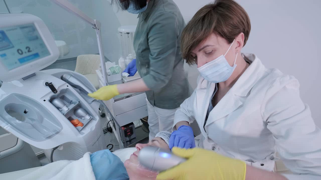 rejuvenecimiento profesional de la piel del rostro, procedimiento de lifting. el cosmetólogo utiliza un dispositivo de ultrasonido moderno. cosmetología de hardware