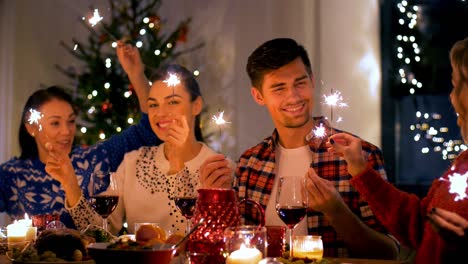 friends with sparklers at home christmas dinner