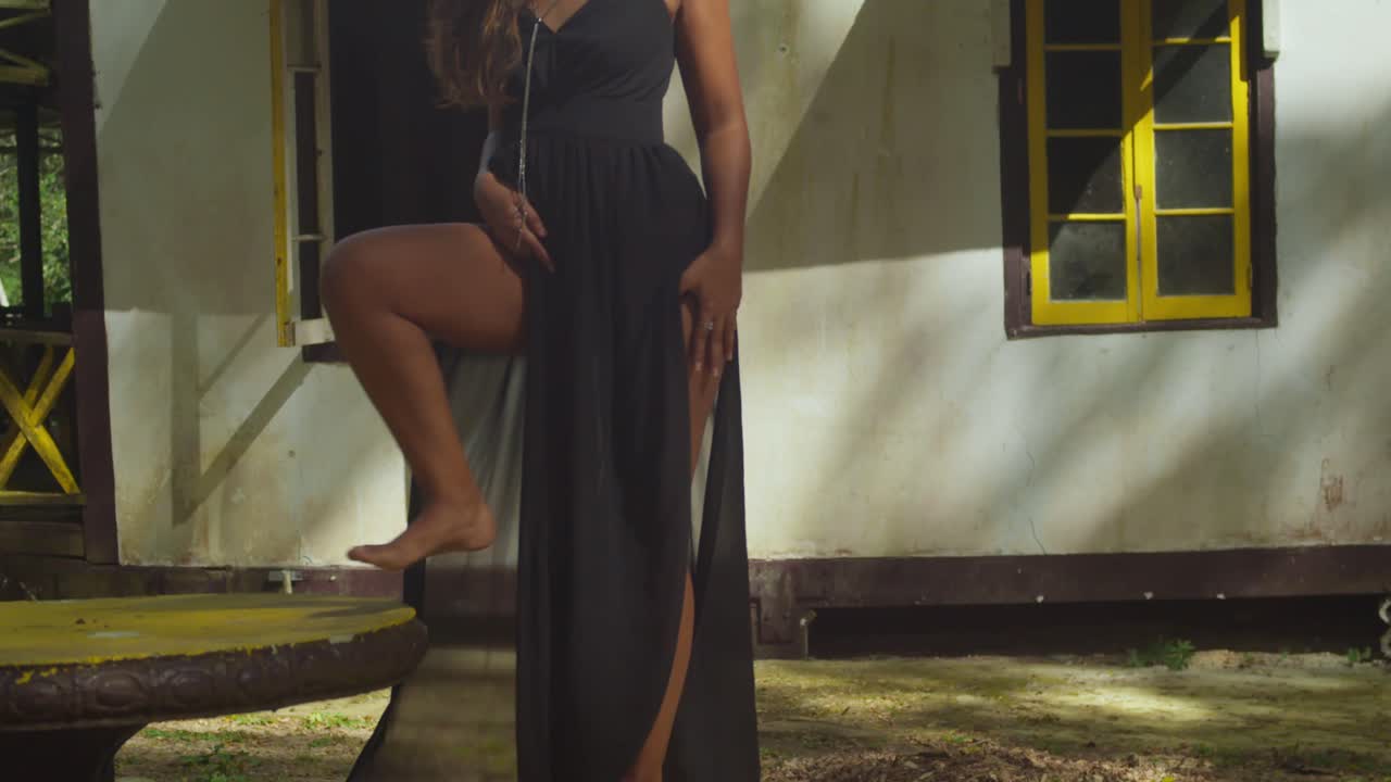 A girl wearing a black dress wanders through a historical site.