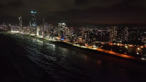 slow motion footage of australias playground, the iconic surfers paradise skyline at night, aerial footage of shimmering lights over crashing waves
