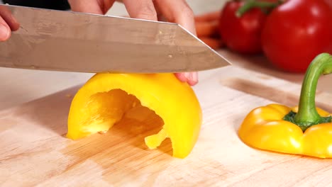 cuchillo para cortar pimienta amarilla con tomates y zanahorias
