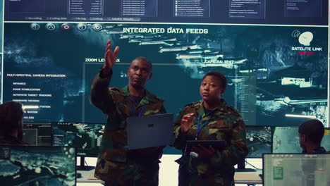 sergeant major and female soldier checking real time field data in command post