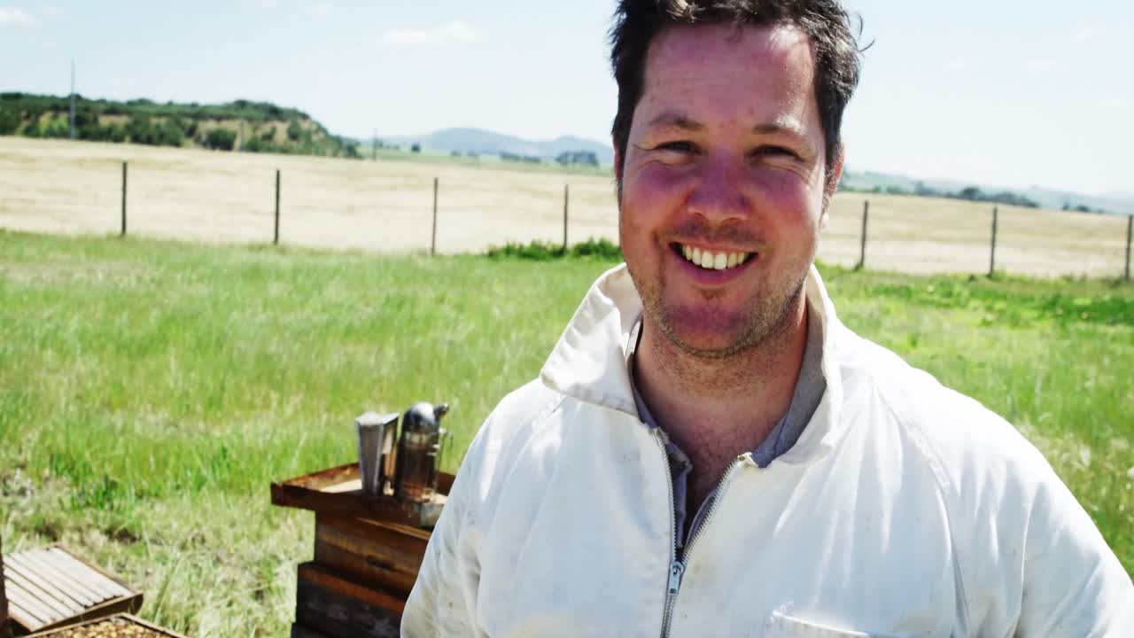 자신감 있는 양봉가 가 카메라 에 미소 짓고 있다