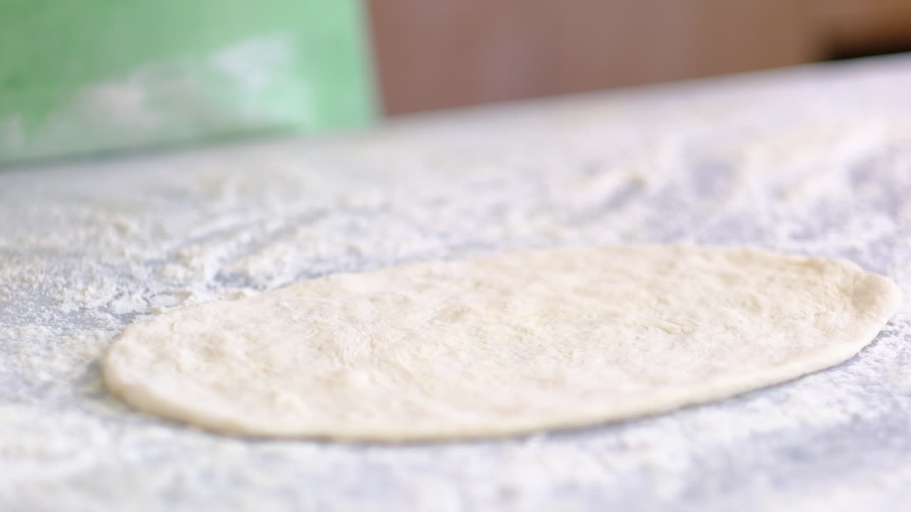 셰프 는 피타 반죽 을 느린 움직임 으로 준비 하고 있다