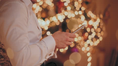 man using digital tablet at illuminated home during christmas