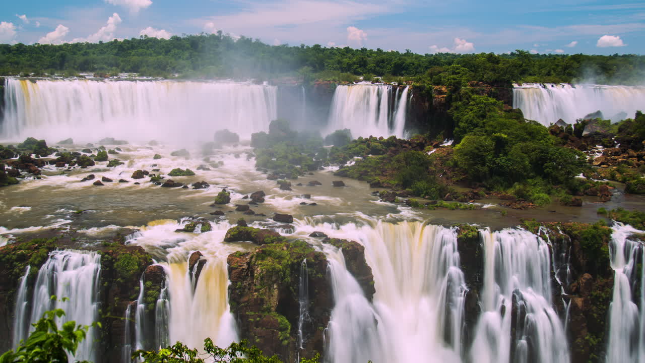 이구아즈 폭포의 타임 스 (time-lapse of iguazu waterfalls around a big green area, in a sunny day, foz do iguaçu, paraná, brazil) 는 브라질의 파라나 주 포즈 도 이구아쿠 (foz do iguacu, parana, brazil) 에서 촬영된 사진이다.