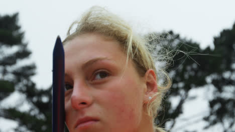 Side-view-of-Caucasian-female-athlete-practicing-javelin-throw-at-sports-venue-4k