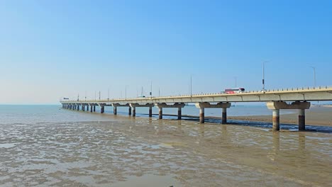 traffic of cars on incheon bridge which stretches elegantly over tidal flats under a clear blue sky, connecting the mainland to incheon international airport with modern infrastructure.