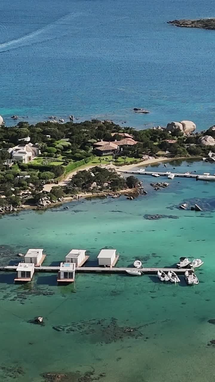 Costa della Sardegna con yacht ormeggiati e acque cristalline visibili