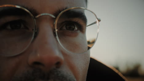 close-up of a focused caucasian young man with glasses enjoying healthy eyesight