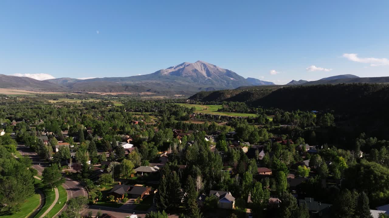 Establishing drone dolly of Carbondale Colorado showing clustered homes and wide foothills leading toward Mount Sopris