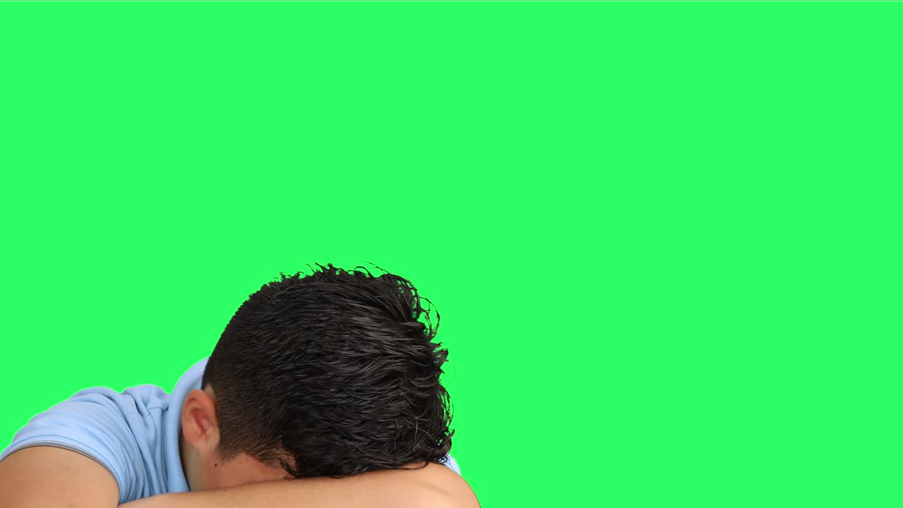 Sad teenager looking at camera at green screen background 2