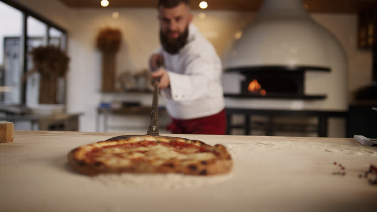 chef italiano haciendo pizza en el restaurante. pastelero sacando comida en el horno.