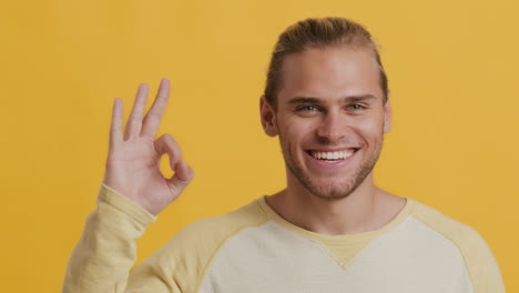 smiling man making ok hand gesture