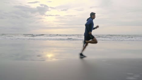 sporty man jogging on sand