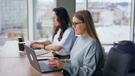 positive young female colleagues work at laptops in the office. calm working atmosphere.
