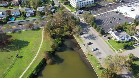 Una-Toma-Aérea-Sobre-Un-Estanque-Verde-En-Un-Barrio-Suburbano-En-Long-Island,-Nueva-York