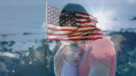 holding baby with american flag overlay, man standing by ocean background