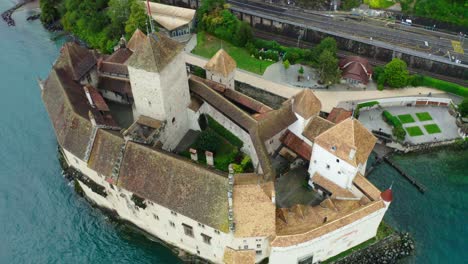 The-drone-camera-is-flying-over-the-castle,-showing-the-garden-inside-the-CASTLE,-beautiful-palce-in-Switzerland