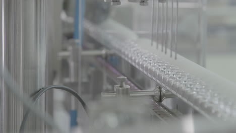 sterile environment with medical vials filled with liquid on a automated conveyor production line in pharmaceutical factory manufacturing plant, showcasing modern medicine laboratory science.