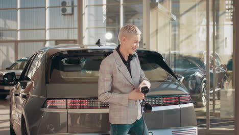 woman excitedly charging electric car