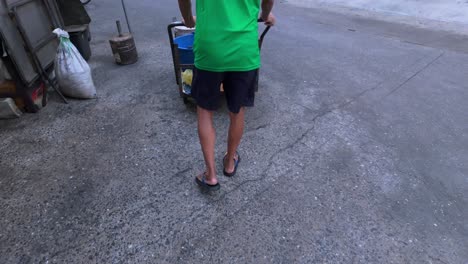 Person Pushing Cart on Street