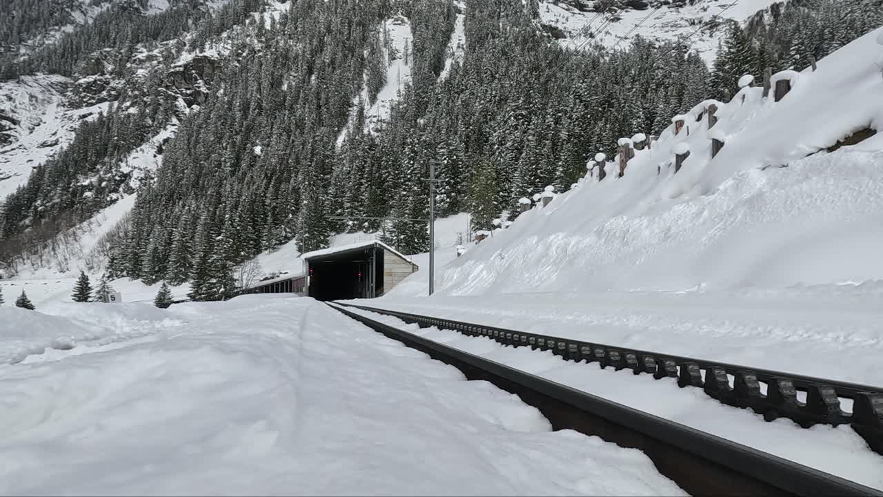 Swiss alpine rail road tracks leading to the train tunnel