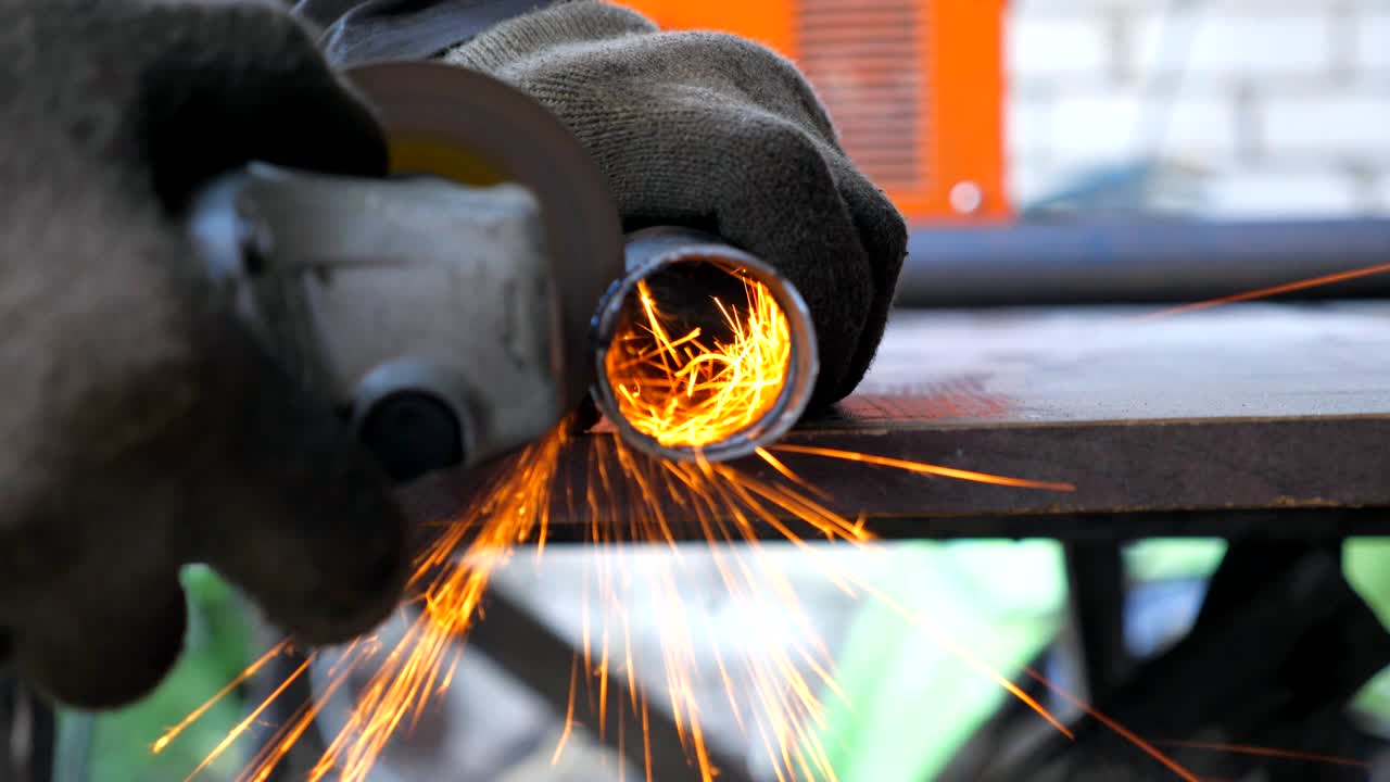 vista detallada del procesamiento de metales con sierra circular y chispas volando por ahí. reparador o mecánico moliendo metal. trabajador cortando algunos detalles de hierro en el garaje o taller. cámara lenta de cerca