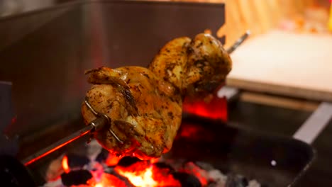 whole roasted chicken meat grilled on fire during barbecue event