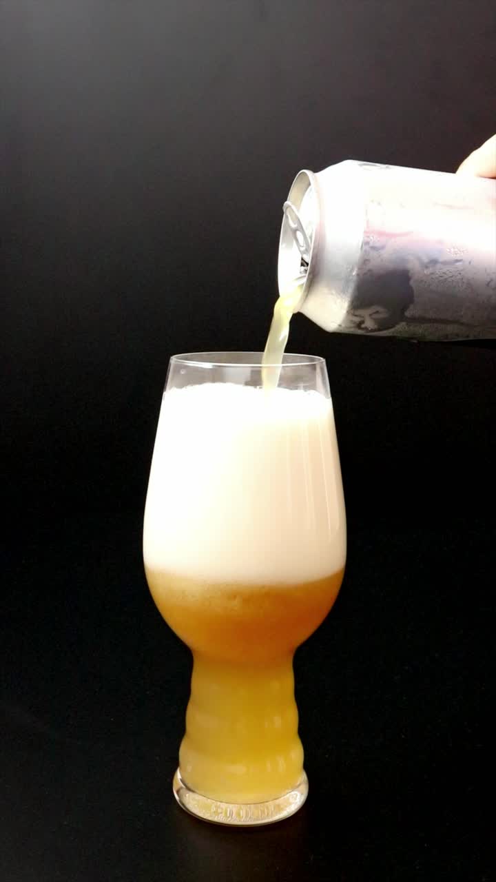 Versare birra artigianale torbida da una lattina in un bicchiere