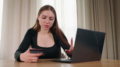 mujer que utiliza una computadora portátil y una tarjeta de crédito para el pago en línea