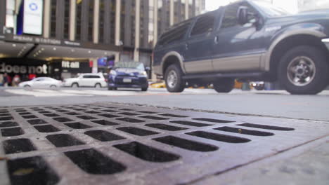 Tráfico-De-La-Ciudad-De-Nueva-York-Conduciendo-Por-La-Calle-Desde-La-Perspectiva-De-La-Alcantarilla-Cuadrada-Durante-El-Día