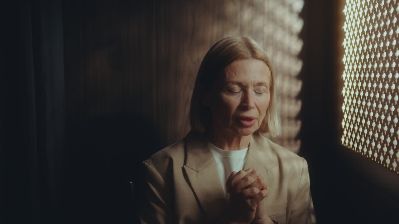 Senior Woman Saying Contrition Prayer during Confession