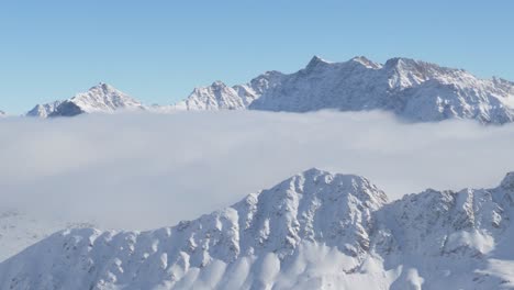 aerial view of a highland valley, covered in fog, sunny, winter day in austria - pan, drone shot