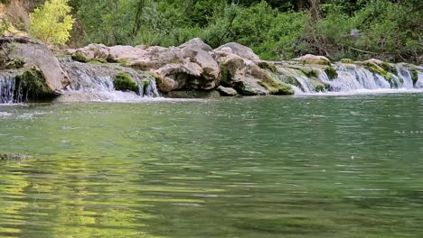 Dieses-Ruhige-Archivmaterial-Zeigt-Einen-Ruhigen-Kleinen-Fluss-Mit-Langsamer-Strömung,-Umgeben-Von-üppigem-Grün