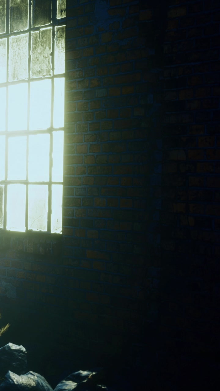 Light streams through a dirty window in an abandoned building during evening