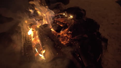 Woman-mending-the-fire-outdoor-in-winter-evening