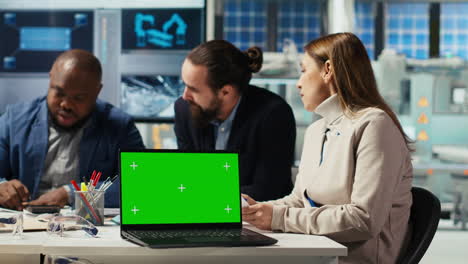 factory engineers using green screen laptop to increase energy output