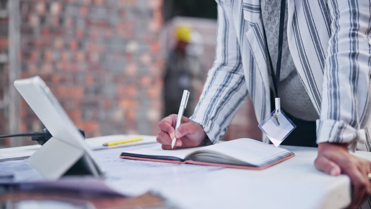 Woman writing in notebook at construction site