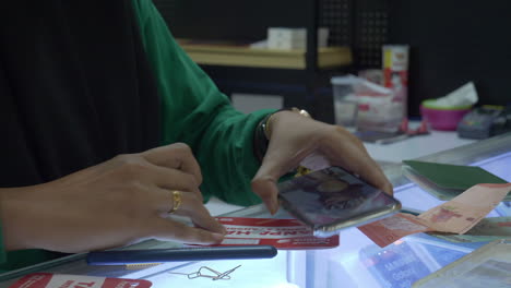 female works on replacing sim card in phone for customer in asia