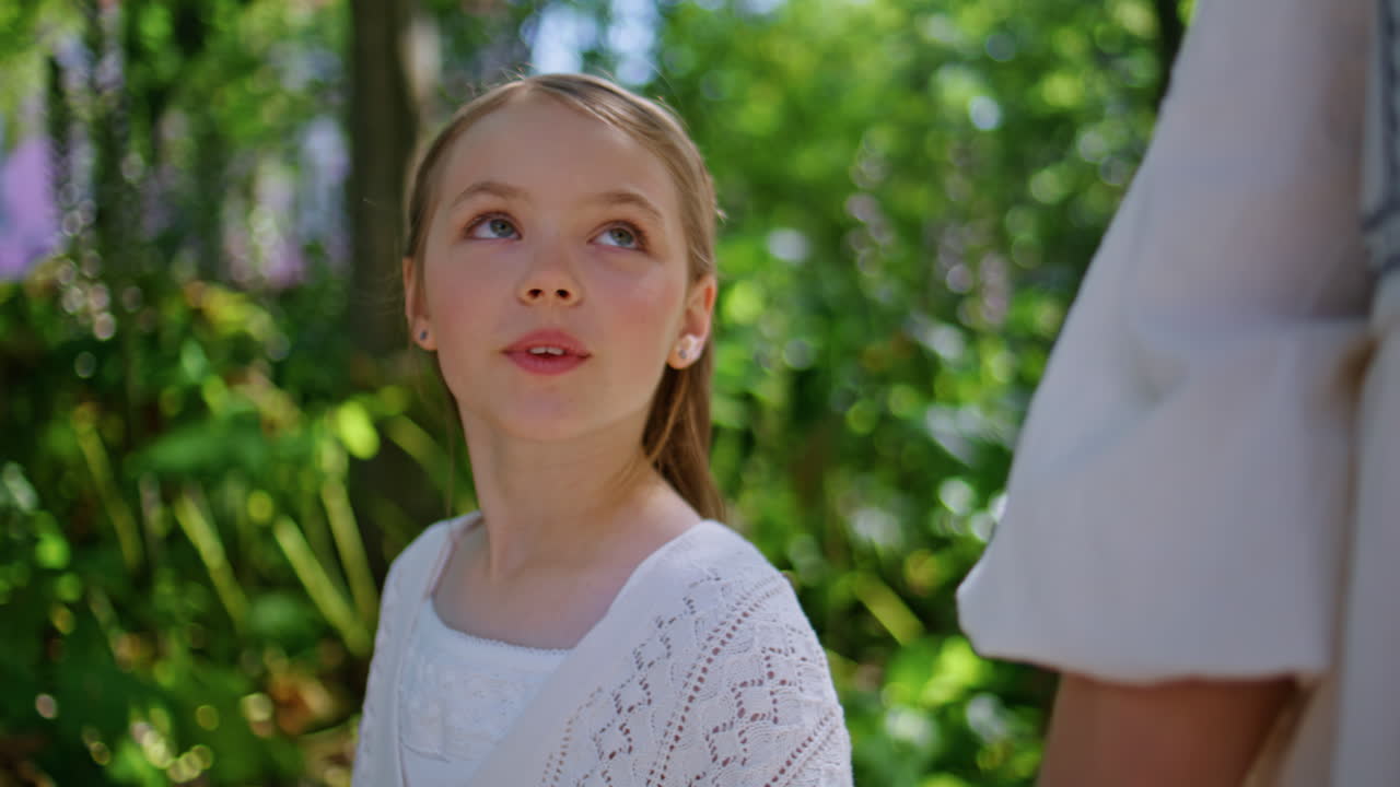 Talking kid walking park unknown mother at sunny day closeup. Woman girl going