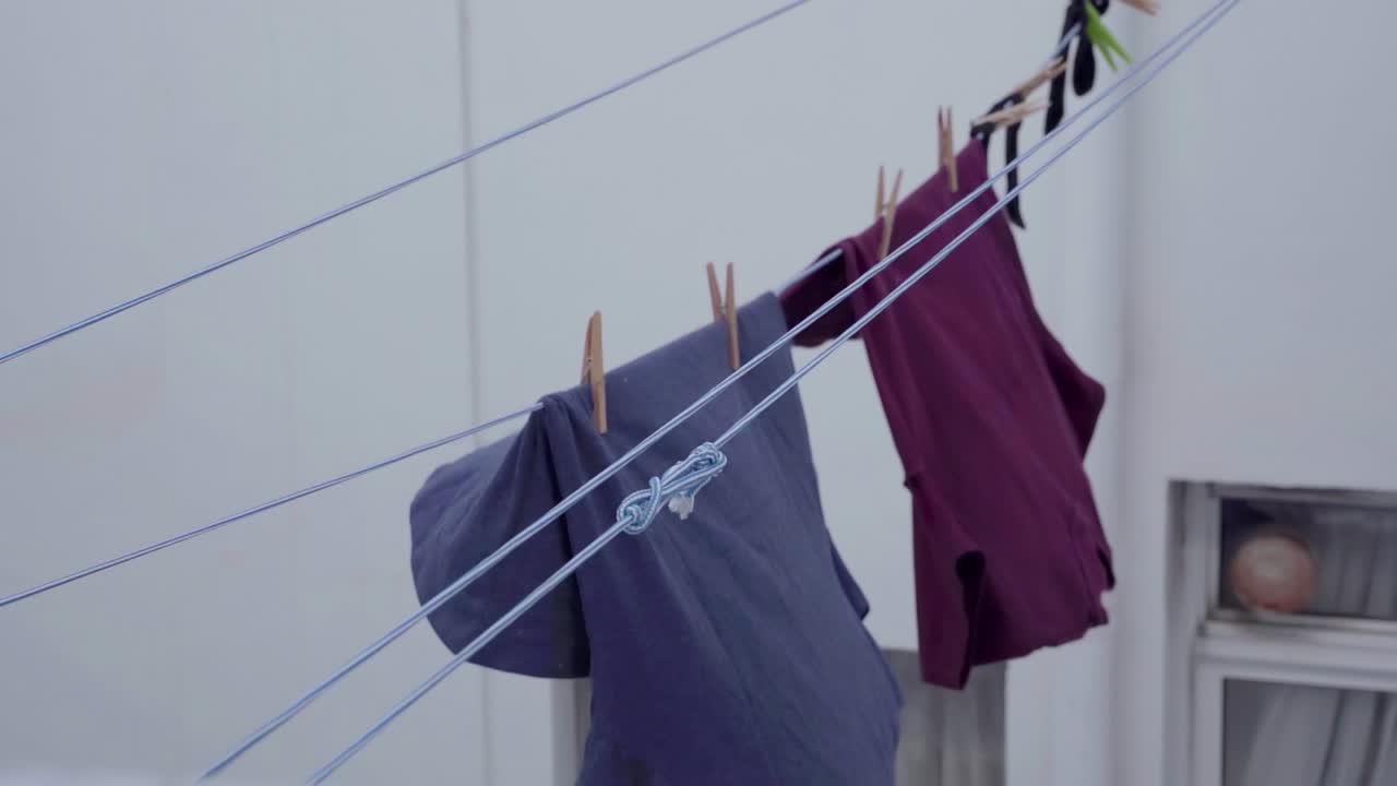 Steady view on laundry hanging on ropes being pulled backwards